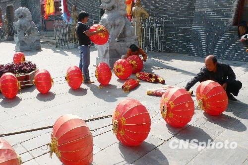 8月31日，河南省開(kāi)封市天波楊府門(mén)口，工作人員在準(zhǔn)備懸掛大紅燈籠。隨著“十一”國(guó)慶節(jié)和“十一”旅游黃金周的臨近，古城開(kāi)封的公園景點(diǎn)已早早開(kāi)始備戰(zhàn)，營(yíng)造喜慶祥和的旅游環(huán)境，迎接八方客人。 中新社發(fā) 李俊生 攝