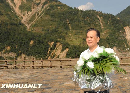 溫家寶總理十分關(guān)注災(zāi)后重建進(jìn)展情況。在國(guó)慶節(jié)和中秋佳節(jié)即將來臨之際，他第8次踏上了一直牽掛的這塊土地。在9月24日至26日的三天時(shí)間里，他奔波穿行于地震重災(zāi)區(qū)的城鄉(xiāng)間，為節(jié)省時(shí)間，吃飯盡量安排在火車上；連續(xù)兩個(gè)晚上主持召開會(huì)議，就災(zāi)后恢復(fù)重建的一系列重大問題進(jìn)行研究部署。這是9月24日，溫家寶在青川縣紅光鄉(xiāng)東河口村地震遺址祭奠臺(tái)獻(xiàn)花。新華社記者黃敬文攝