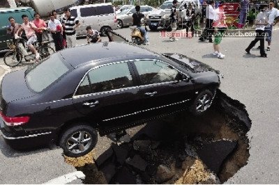 4日，南昌市昌南大道與迎賓北大道交叉口附近路面突然發(fā)生塌陷，一輛過路小轎車被卡在洞口處。圖/新華社