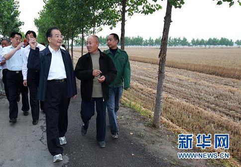 這是6月9日，溫家寶在長(zhǎng)葛市石象鄉(xiāng)坡李王村的田間小路上與坡李王村支部書記李福成邊走邊聊。新華社記者龐興雷攝