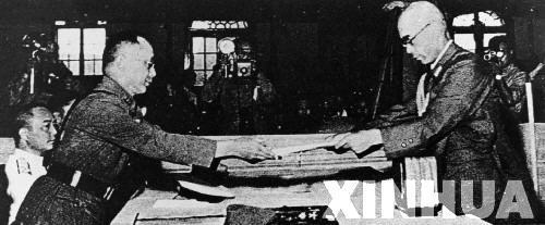 日本中國派遣軍總司令官岡村寧次在對華投降書上簽字，并向中方交出他的隨身佩刀，以表示侵華日軍正式向中國繳械投降。這是何應(yīng)欽(左)在南京代表中國政府接受侵華日軍總司令岡村寧次的投降書。新華社發(fā)