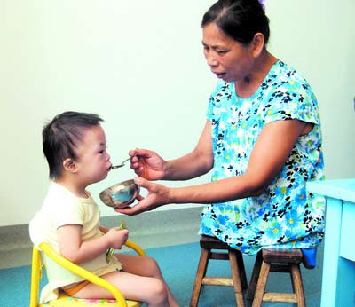 許月華在給孩子喂飯。劉炬 攝