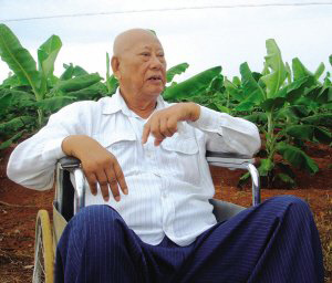 陳光保在自己的農(nóng)場里，他身后就是一片香蕉林(中青報蔣昕捷供圖)