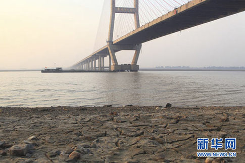 這是12月10日在江西省湖口縣境內(nèi)的鄱陽湖大橋附近拍攝的已經(jīng)干涸開裂的湖灘。