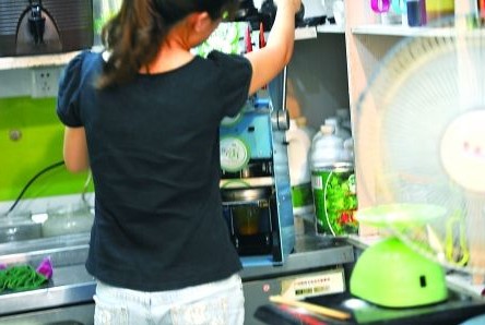 昨日，沙坪壩區(qū)一飲料店，店員在用添加劑勾兌果汁