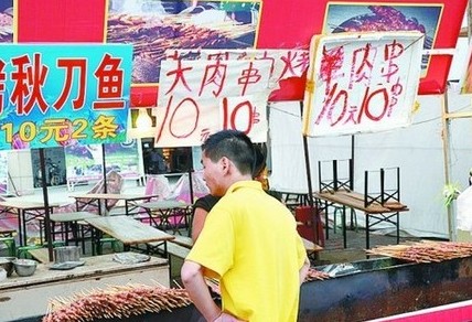 被查后，美食街上的'羊肉串'的'羊'字被涂抹了。