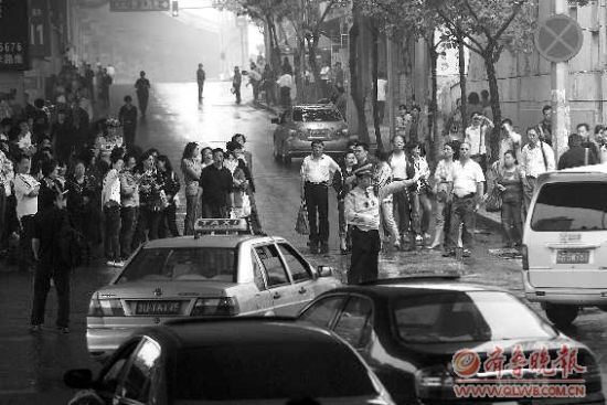  8日，在青島15中考點外，家長排起人墻堵路，交警只能指揮途經車輛繞行。 本報記者 楊寧 張曉鵬 攝