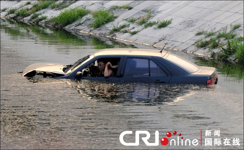 車(chē)沖入河中，依稀可見(jiàn)車(chē)中兩名男子正在打斗。