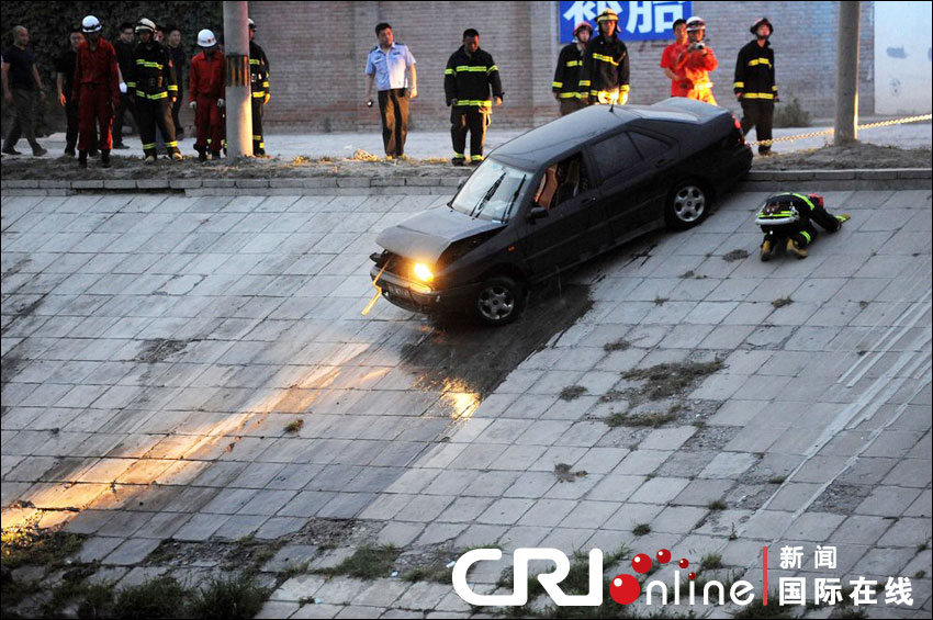 2012年6月17日下午，北京四元橋下方的西壩河輔路上，一輛轎車失控墜河中。消防員將轎車拖上岸。
