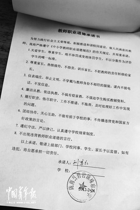 劉軍紅簽字的教師職業(yè)道德承諾書。本報記者 張鵬攝