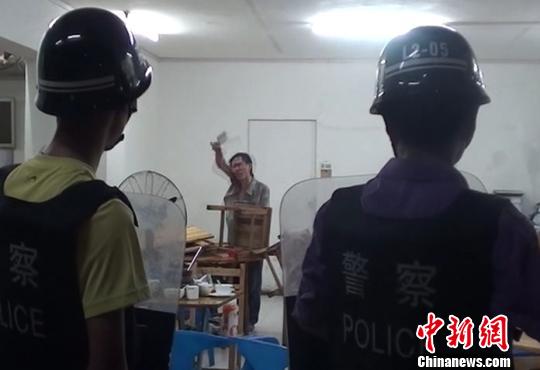 圖為涉嫌販毒的男子持菜刀在宵夜店與民警對峙。 劉志強 攝