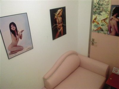 取精室內，有一個粉色沙發(fā)，墻壁四周掛著女體畫