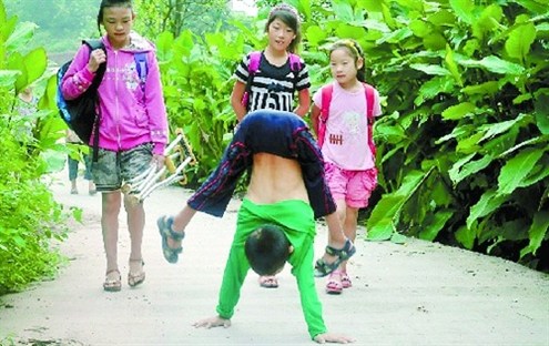 倒立行走去上學(xué) 堅(jiān)強(qiáng)癱瘓男孩感動(dòng)網(wǎng)友。圖據(jù)山東商報(bào)