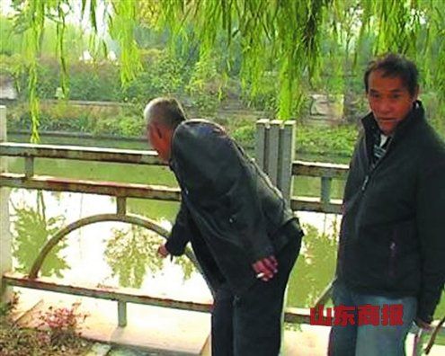 目擊者給記者指認孩子落水的位置。