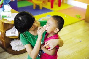 2012年9月3日，浙江一所幼兒園，老師幫孩子擦鼻涕。