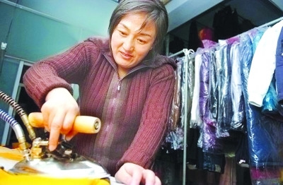資料圖：鄒春蘭在自己洗衣店內工作。圖片來源 揚子晚報