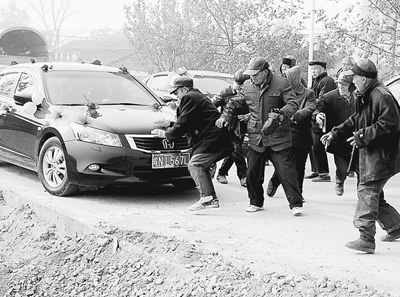 一些老人蜂擁而上圍堵婚車。