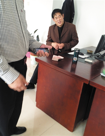 10月29日，獻(xiàn)縣國稅局稽查局辦公室內(nèi)，一名企業(yè)主交了兩萬元現(xiàn)金在桌上。新京報記者 孟祥超 攝