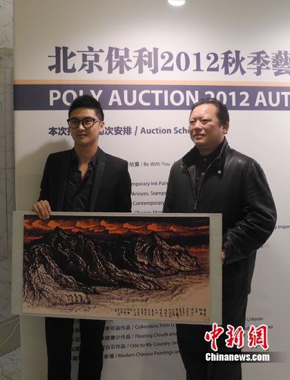 田亮與畫家洪潮合影，兩人展示《夢縈釣魚島》縮小版。