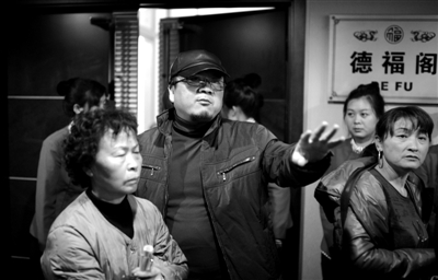 昨日，在河北香河天下第一城，相關(guān)負(fù)責(zé)人（左二）走出會議室與參加演出的老人們溝通。