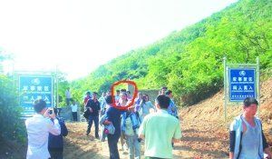 被困女子（圈中）獲救后從山嶺入口處豎有“軍事禁區(qū)”的標(biāo)牌旁通過。