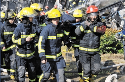 消防官兵將受傷的同事抬出。陳福 攝