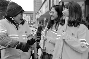 1月8日，22歲的王雪菁（右）和23歲的陶晨露（中）陪著她們的環(huán)衛(wèi)工人師傅鄧桂鸞聊天 新華社發(fā)