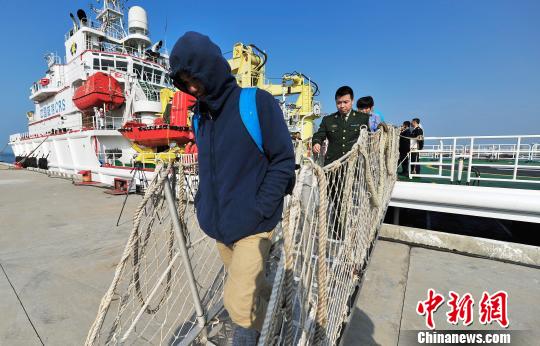 圖為24名“驢友”的“導(dǎo)游”被邊防的工作人員帶下船接受調(diào)查。 駱云飛 攝