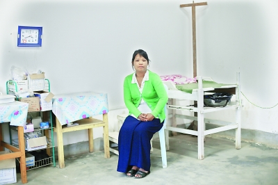 老三的愛人是當(dāng)?shù)匾幻t(yī)生，他們的小診所可以免費(fèi)為艾滋病人提供藥品，她身后是一個(gè)孕婦生產(chǎn)的手術(shù)臺(tái)。