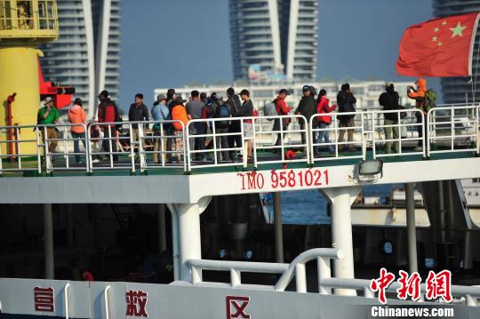 圖為24名“驢友”的“導(dǎo)游”被邊防的工作人員帶下船接受調(diào)查。 駱云飛 攝