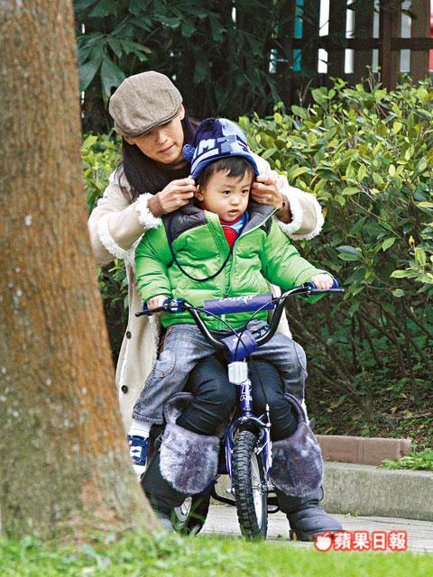 張柏芝抱quintus坐踩單車，又細(xì)心幫他整理冷帽