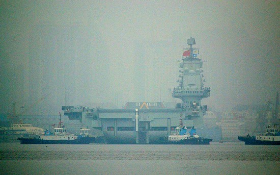 資料圖：大連港口大霧彌漫，中國首艘航母“遼寧艦”徐徐離開港口。