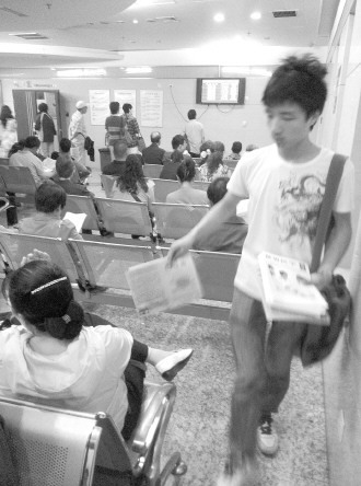 發(fā)報人員正在候診大廳散發(fā)虛假宣傳品。 本報記者 楊晉峰 攝