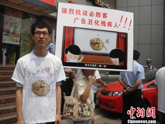 6月5日，視障人士在鄭州一必勝客門前舉牌抗議蝦球廣告歧視。 門杰丹 攝